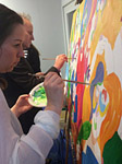 Samen schilderen aan schilderij tijdens personeelsfeest